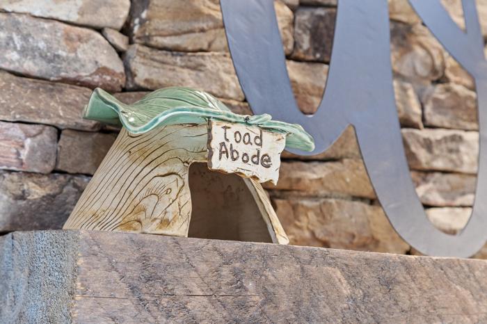 A wooden structure with a sign that reads &lsquo;Toad Abode.&rsquo;