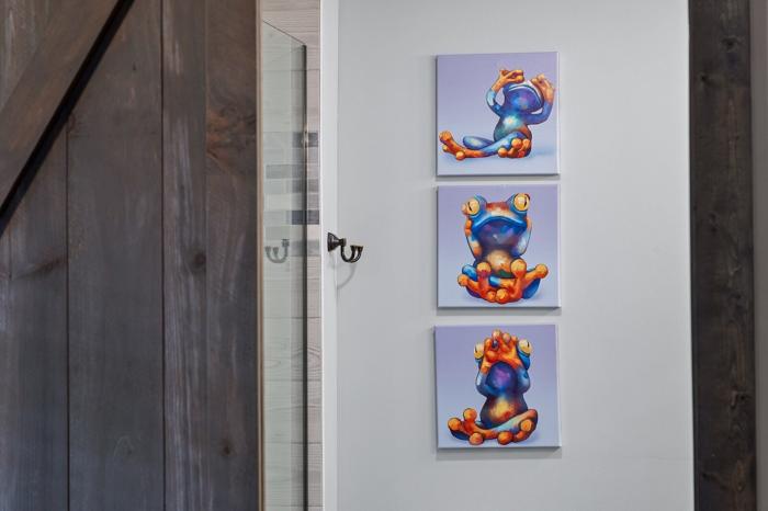 A hallway with three abstract paintings on the wall.