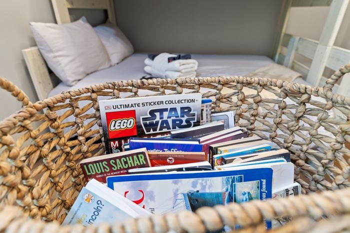 A wicker basket filled with books and a LEGO Star Wars sticker collection.