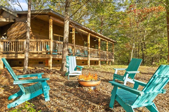 A wooden cabin with a porch, outdoor seating, and a fire pit.