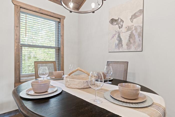 A dining area with a table set for four, including bowls, plates, and wine glasses.