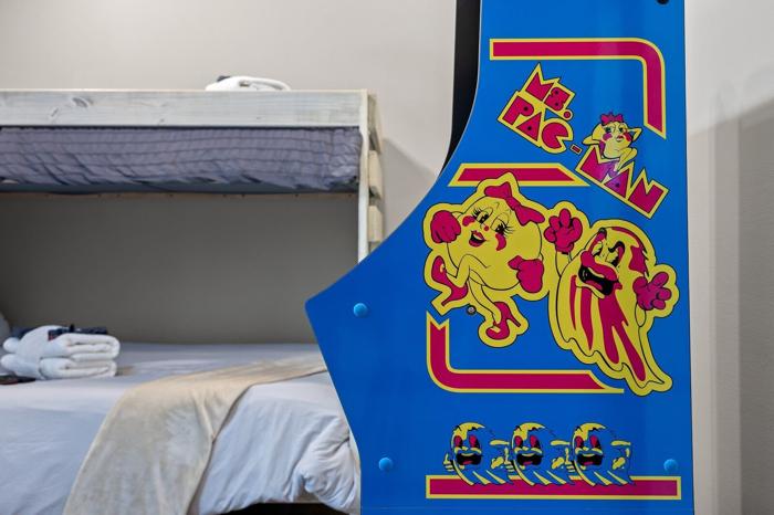 A bunk bed with a white mattress and a blue wall with cartoon character stickers.